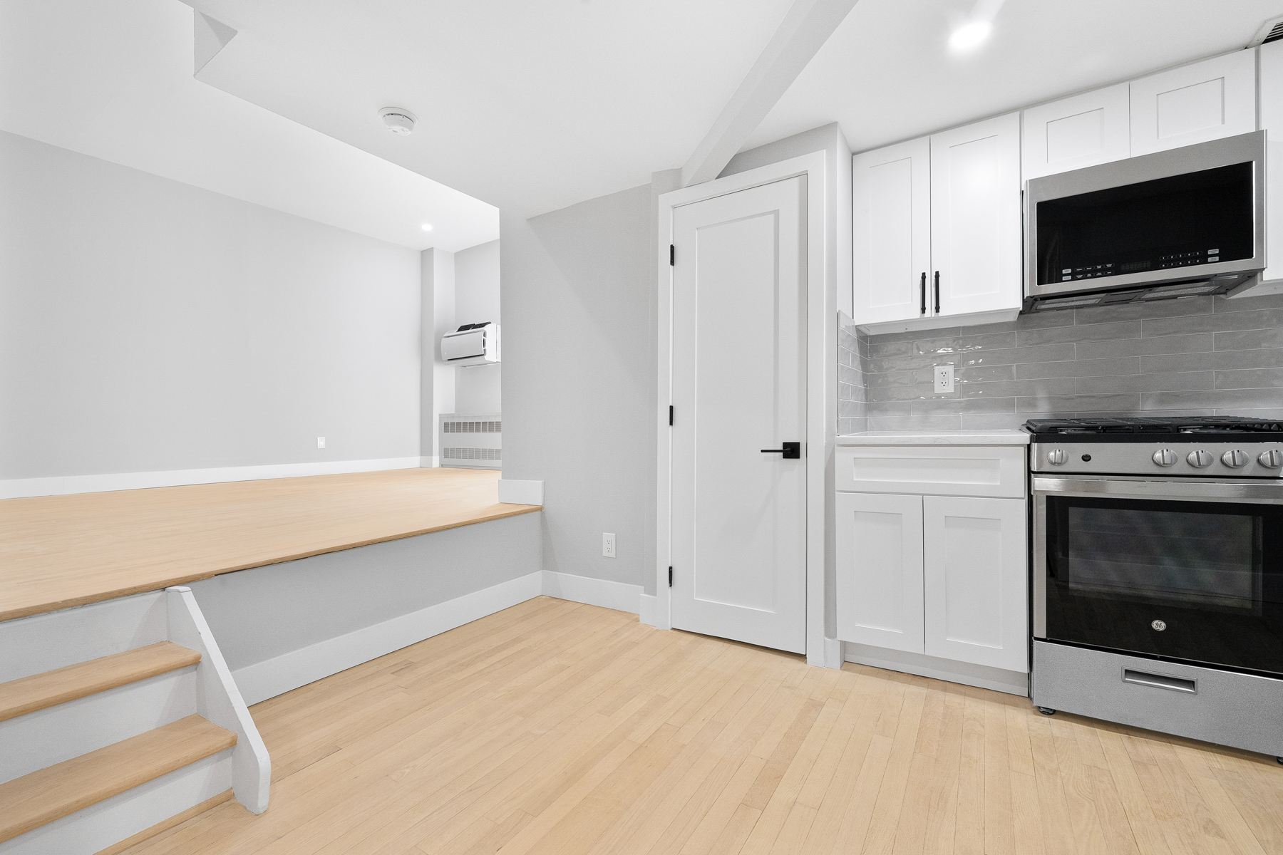 184 Thompson Street, Unit 2V Manhattan, NY 10012 - Photo 4 of 8 a view of an empty room with a fireplace and a window