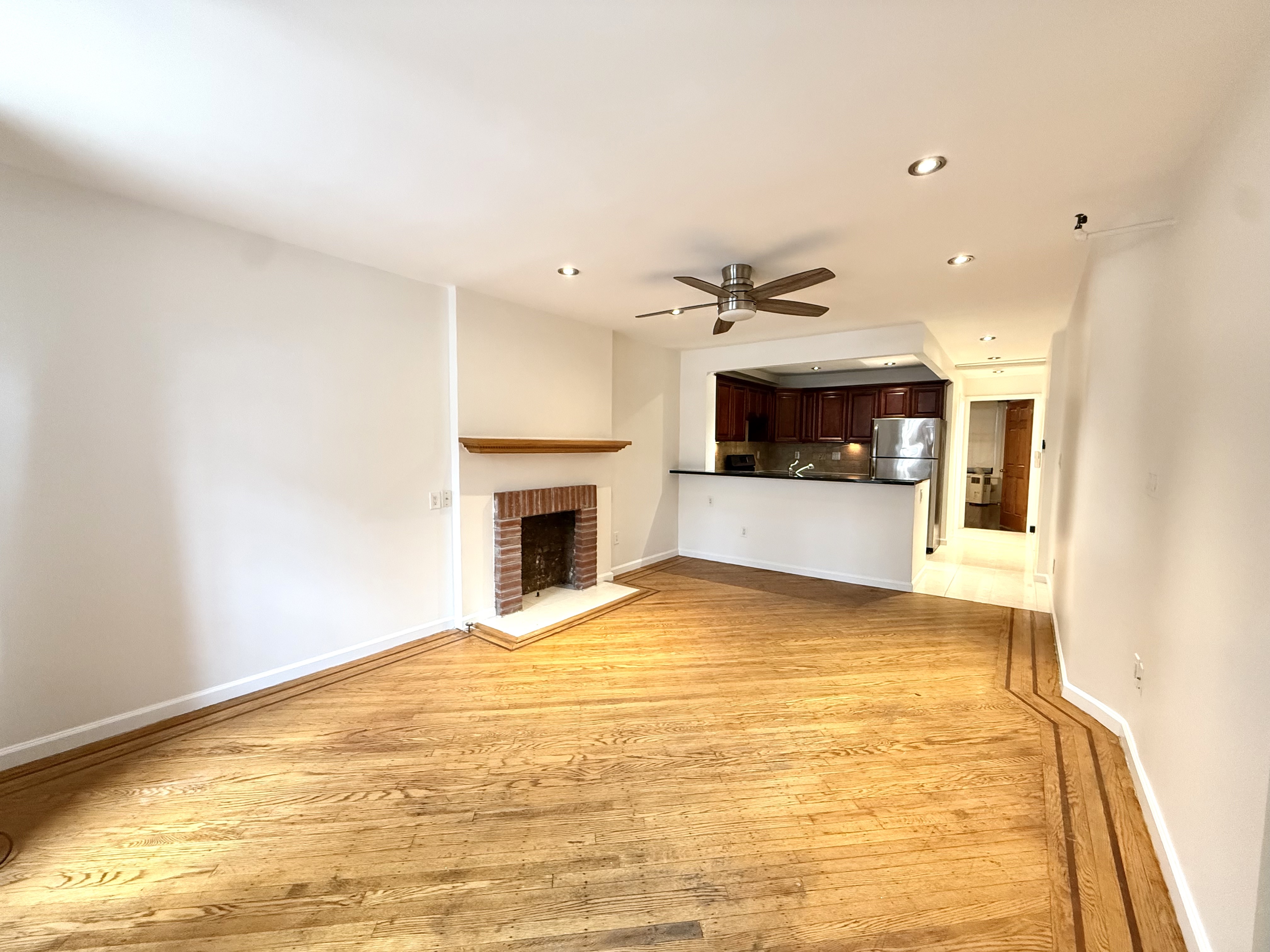 433 West 162nd Street, Unit 1 Manhattan, NY 10032 - Photo 3 of 13 a view of an empty room with a fireplace
