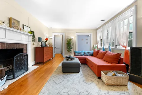 a living room with furniture a fireplace and a large window