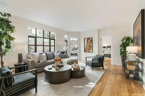 a living room with furniture and a wooden floor