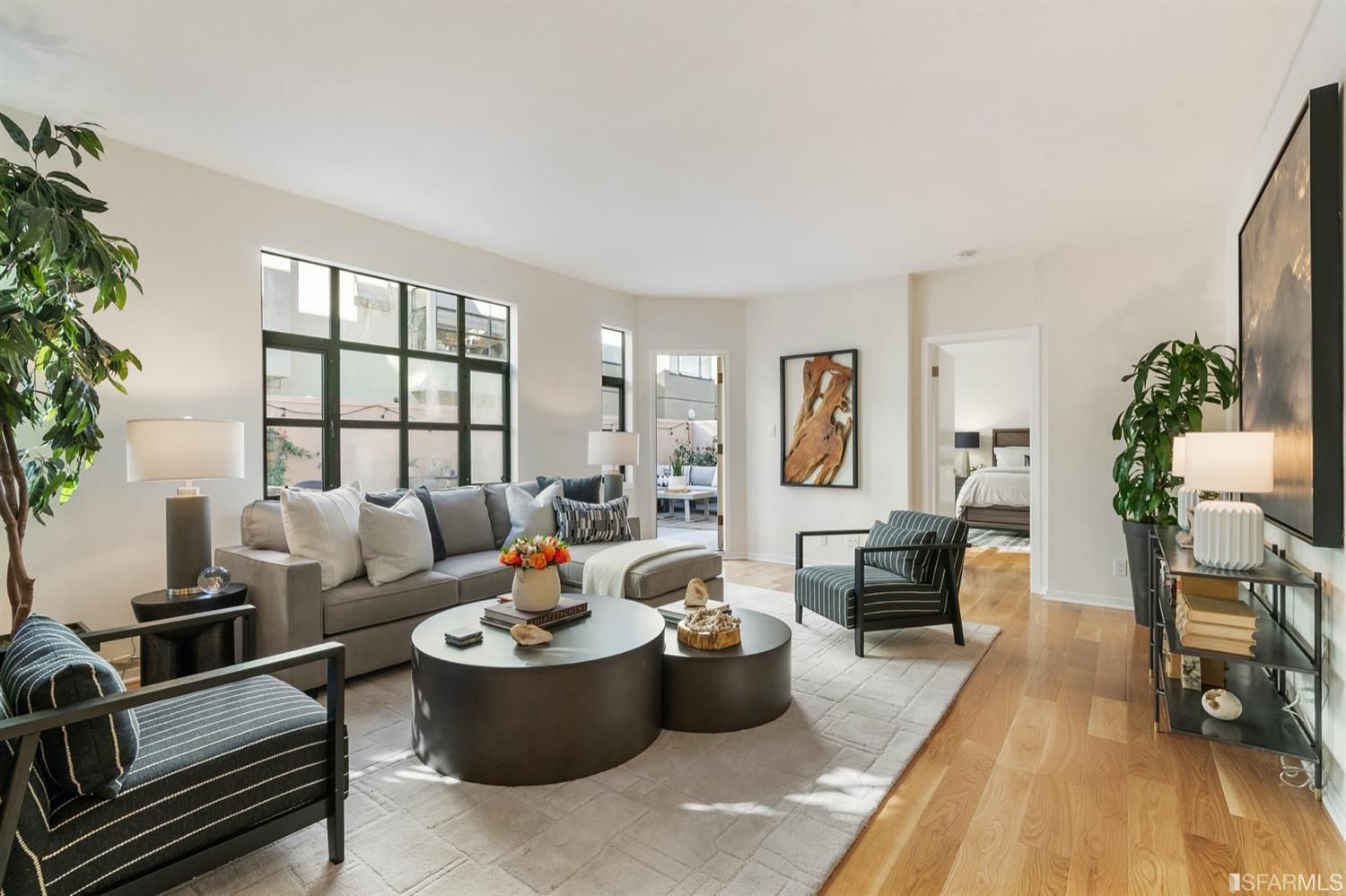 a living room with furniture and a wooden floor