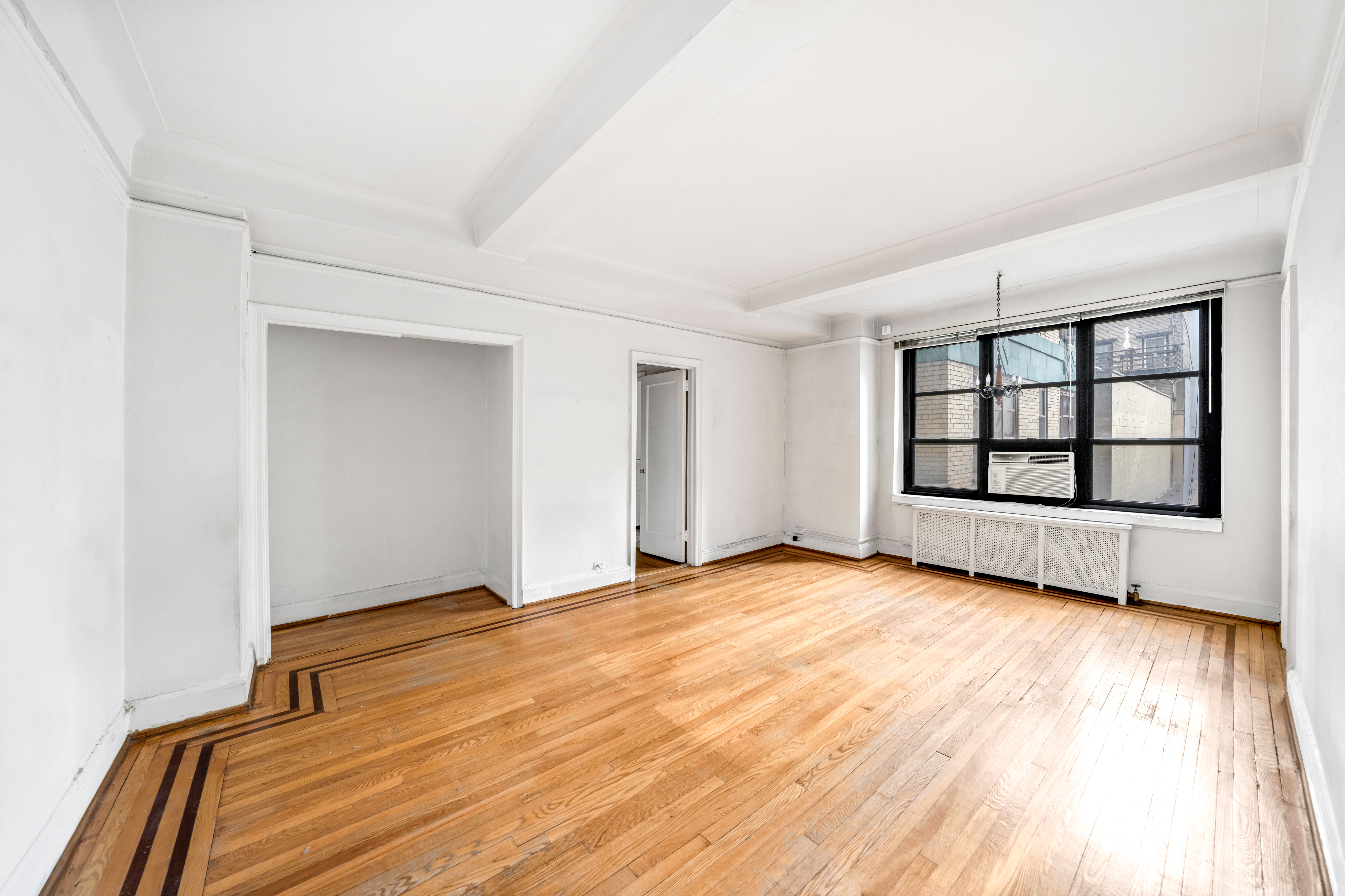 235 East 22nd Street, Unit 2R Manhattan, NY 10010 - Photo 3 of 15 a view of an empty room with window and wooden floor