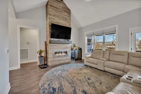 a living room with furniture a fireplace and a flat screen tv