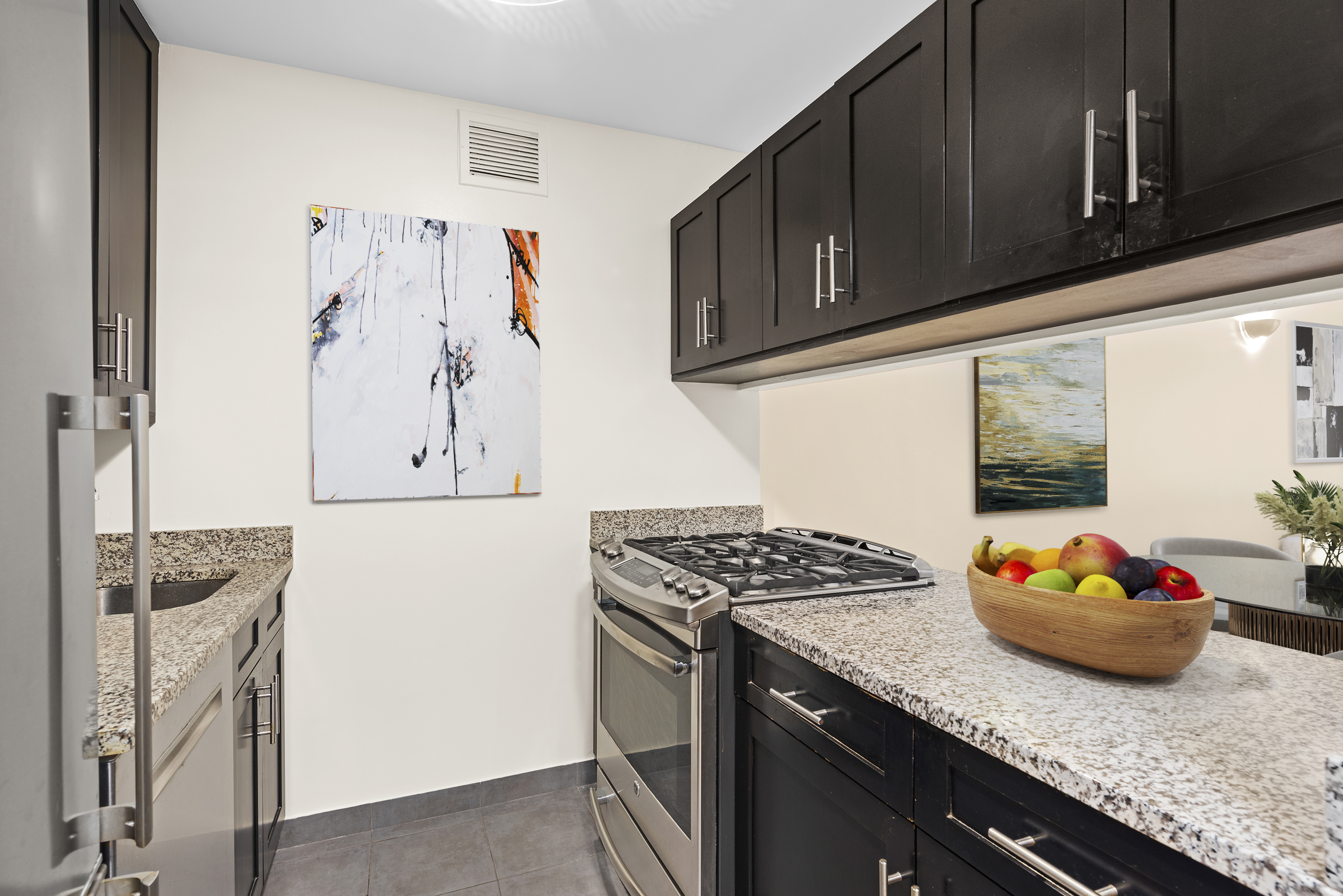 280 Rector Place, Unit 5O Manhattan, NY 10280 - Photo 3 of 7 a kitchen with stainless steel appliances granite countertop a sink stove and cabinets
