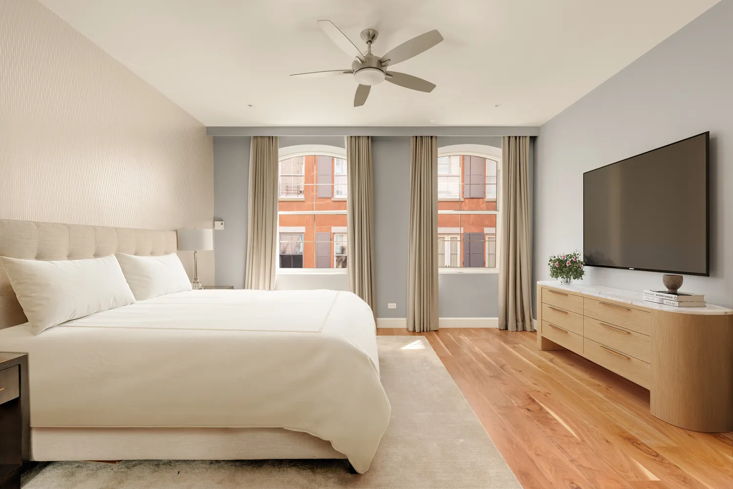 a bedroom with a bed and a flat screen tv on dresser