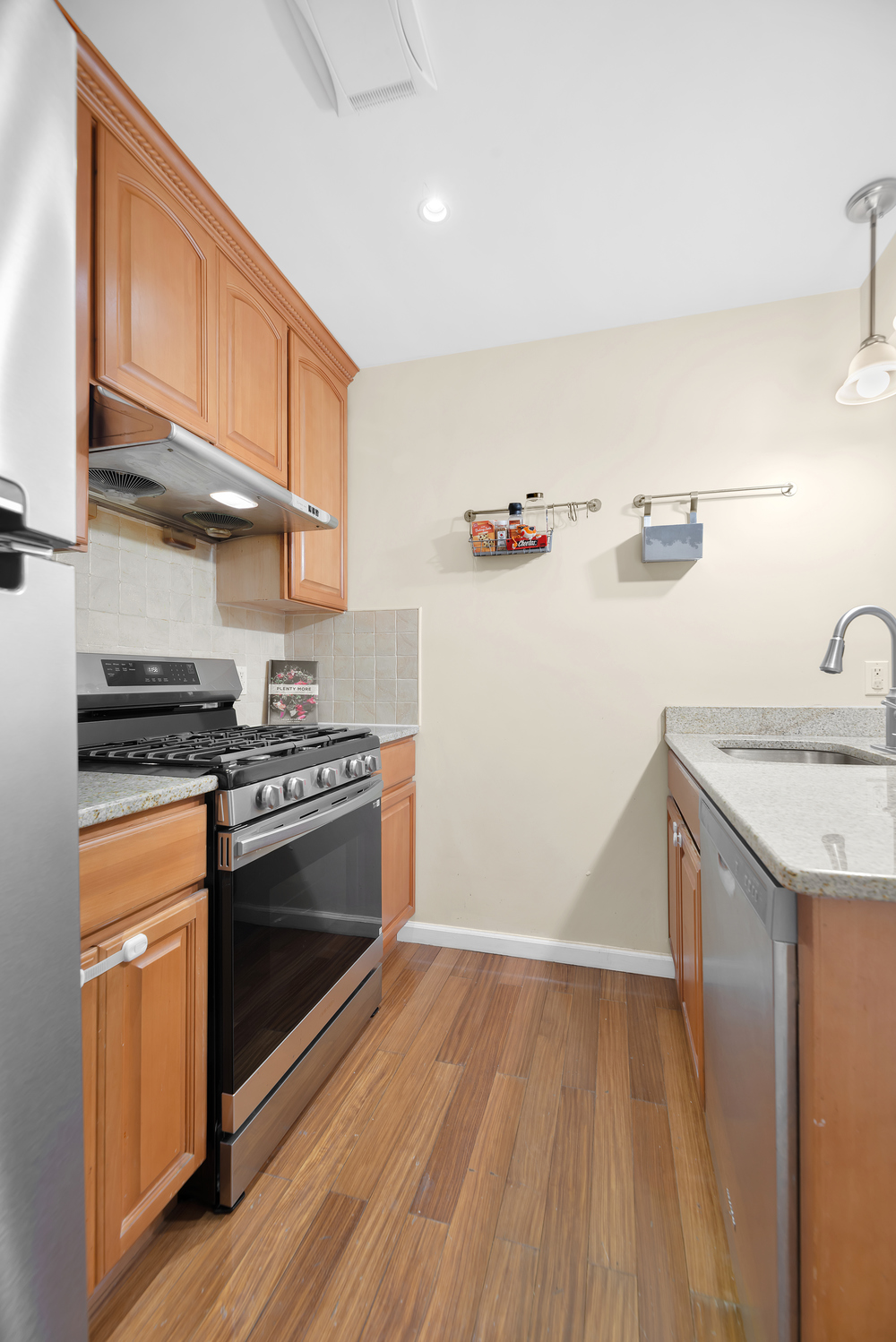 43-33 42nd Street, Unit 6B Queens, NY 11104 - Photo 4 of 8 a kitchen with granite countertop a sink and a stove top oven