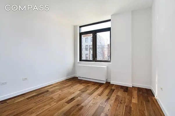 125 North 5th Street, Unit 2E Brooklyn, NY 11249 - Photo 4 of 11 a view of an empty room with wooden floor and a window