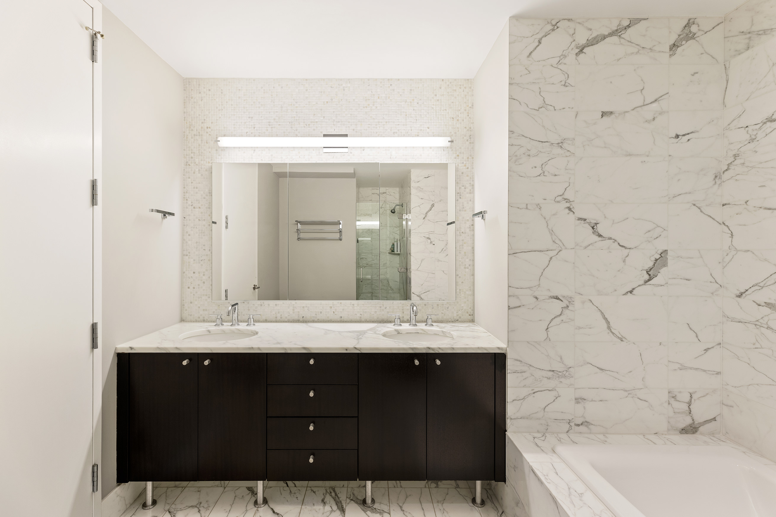 46-30 Center Boulevard, Unit 610 Queens, NY 11109 - Photo 4 of 19 a bathroom with a granite countertop bathtub sink and mirror