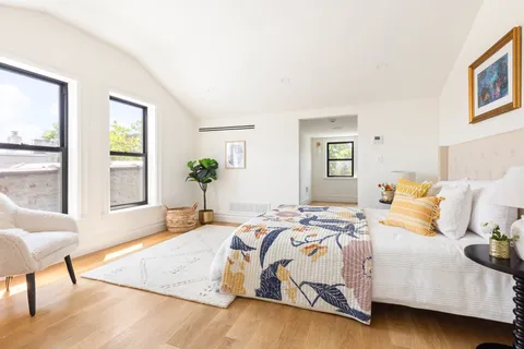 a bedroom with a bed and wooden floor