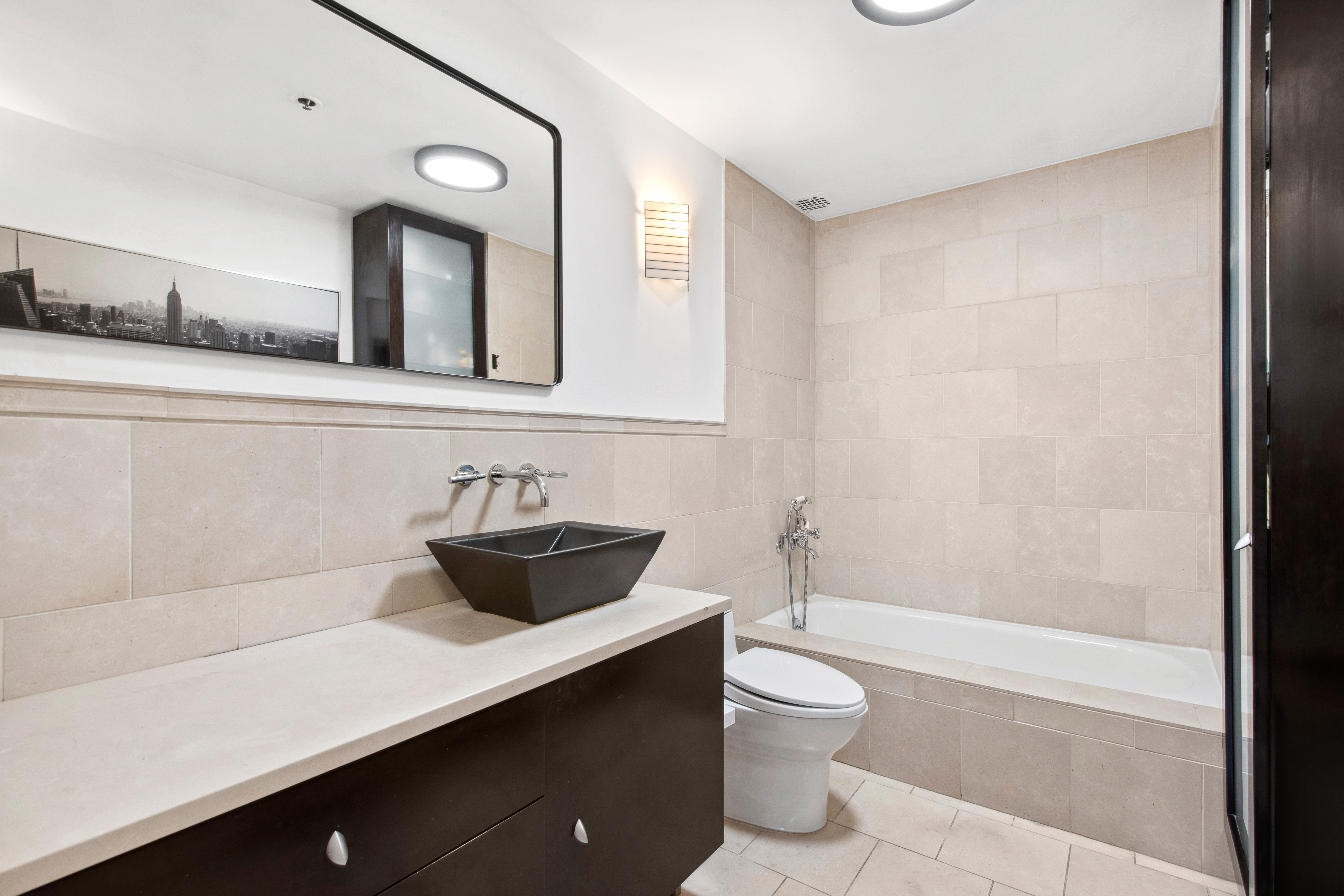 112 West 18th Street, Unit 2A Manhattan, NY 10011 - Photo 7 of 10 a bathroom with a granite countertop sink a toilet and shower