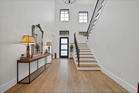 a view of a hallway with wooden floor and staircase
