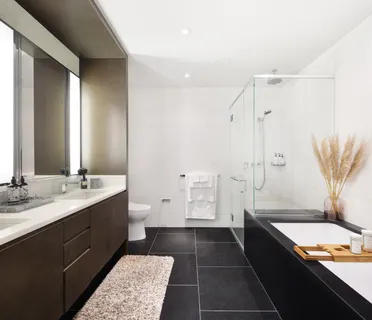 a bathroom with a double vanity sink a toilet and a shower