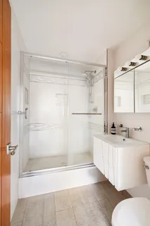a bathroom with a sink a toilet a mirror and shower
