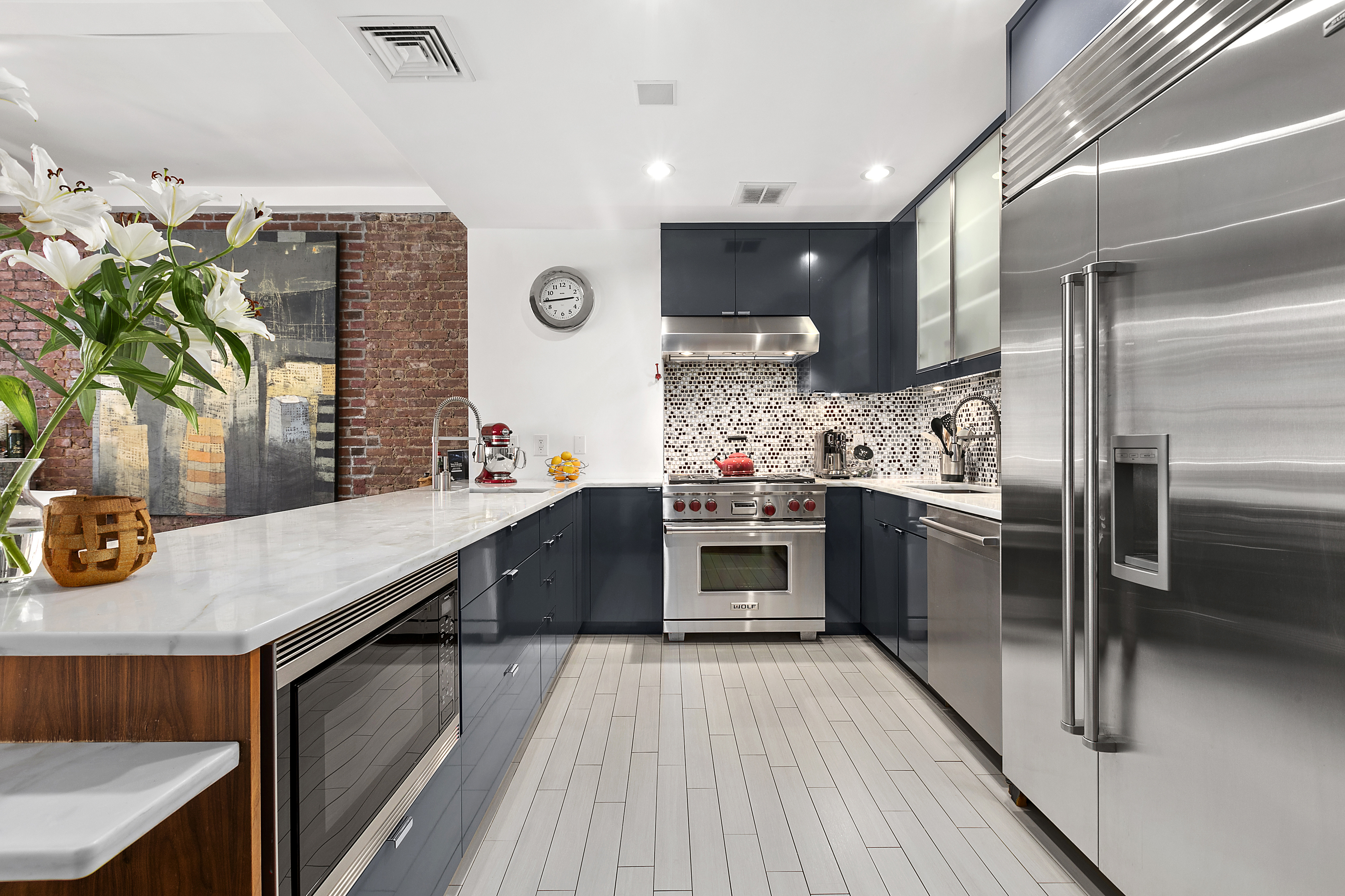 15 West 17th Street, Unit 6 Manhattan, NY 10011 - Photo 4 of 9 a kitchen with stainless steel appliances kitchen island granite countertop a stove a sink and a refrigerator