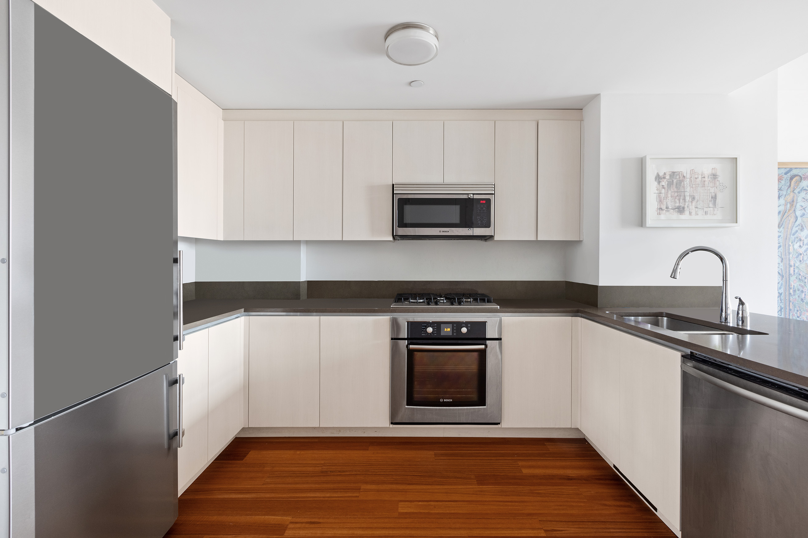 57 Reade Street, Unit 14C Manhattan, NY 10007 - Photo 7 of 16 a kitchen with stainless steel appliances granite countertop a stove a sink and a microwave