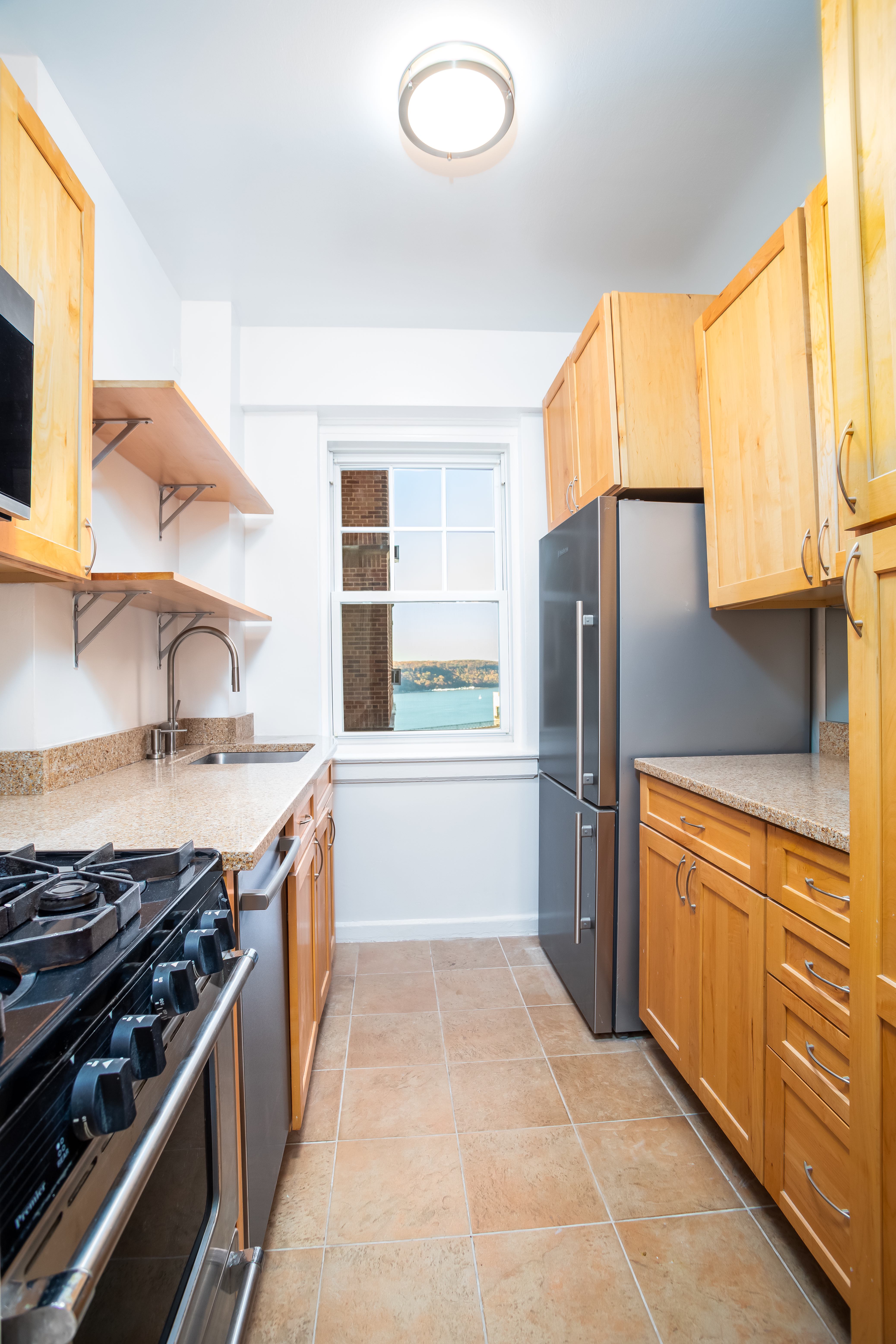 180 Cabrini Boulevard, Unit 37 Manhattan, NY 10033 - Photo 11 of 35 a kitchen with stainless steel appliances granite countertop a stove a refrigerator and a sink