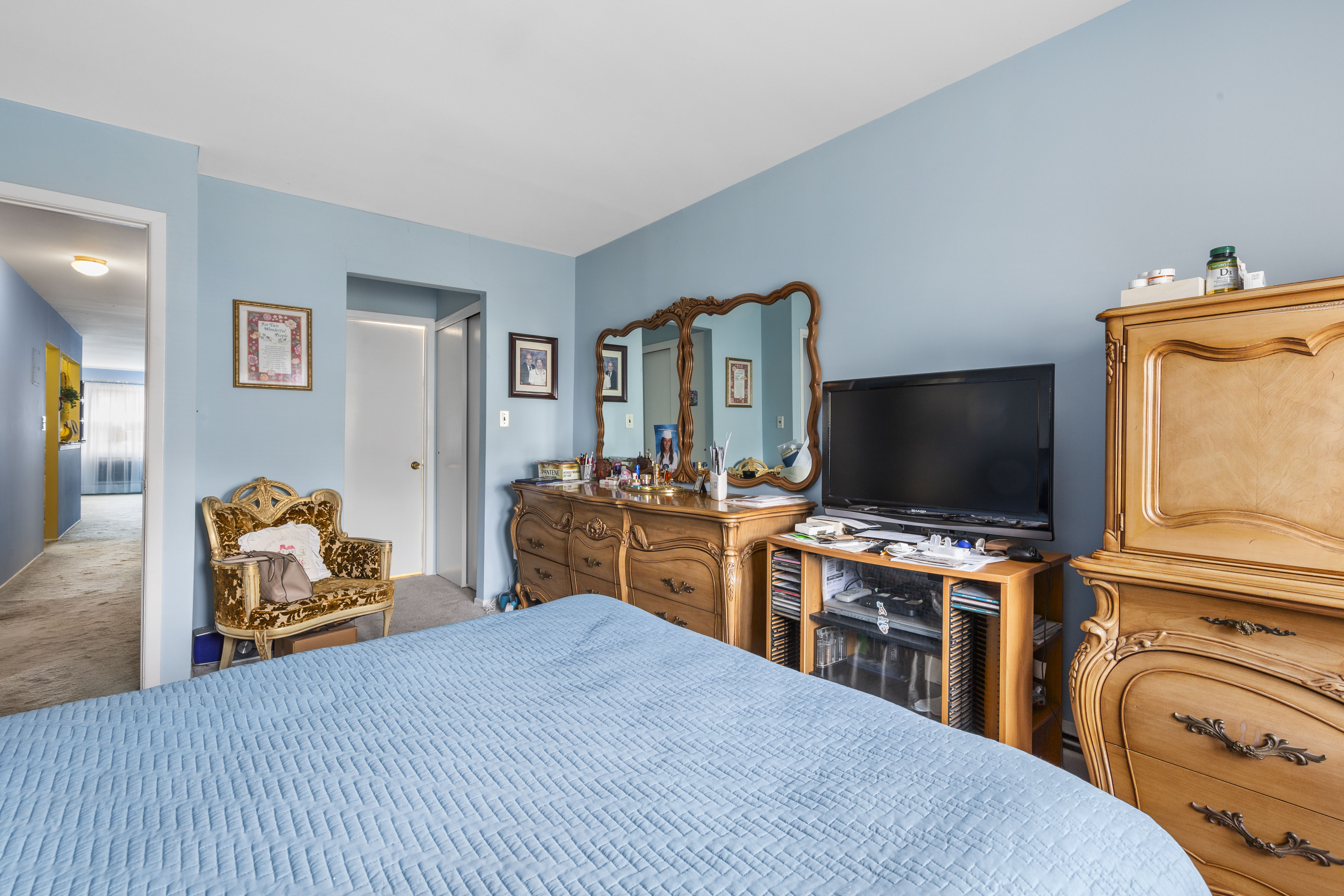 240-47 68th Avenue Queens, NY 11362 - Photo 10 of 39 a bedroom with a bed and a flat tv screen on wall