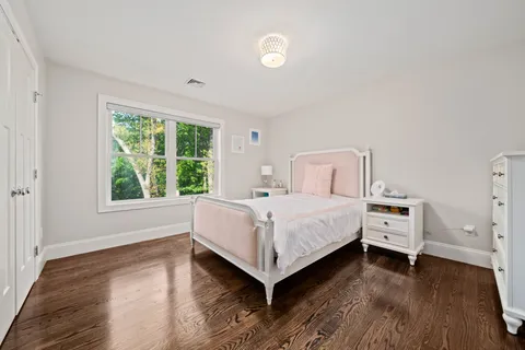 a spacious bedroom with a large bed and a chandelier