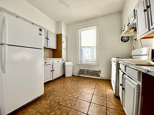 6825 7th Avenue, Unit 2 Brooklyn, NY 11220 - Photo 3 of 10 a kitchen with stainless steel appliances a refrigerator sink and cabinets