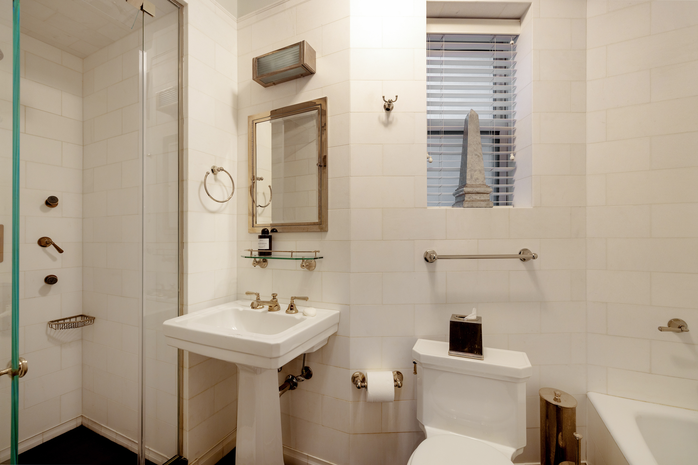 419 East 57th Street, Unit 6A Manhattan, NY 10022 - Photo 9 of 13 a bathroom with a sink a toilet and a mirror