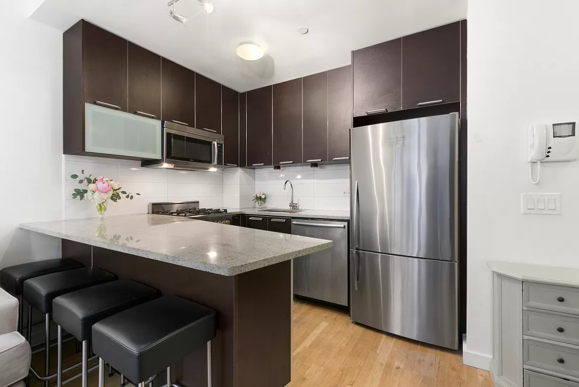 502 9th Avenue, Unit 5A Manhattan, NY 10018 - Photo 2 of 5 a kitchen with kitchen island a sink stove and refrigerator