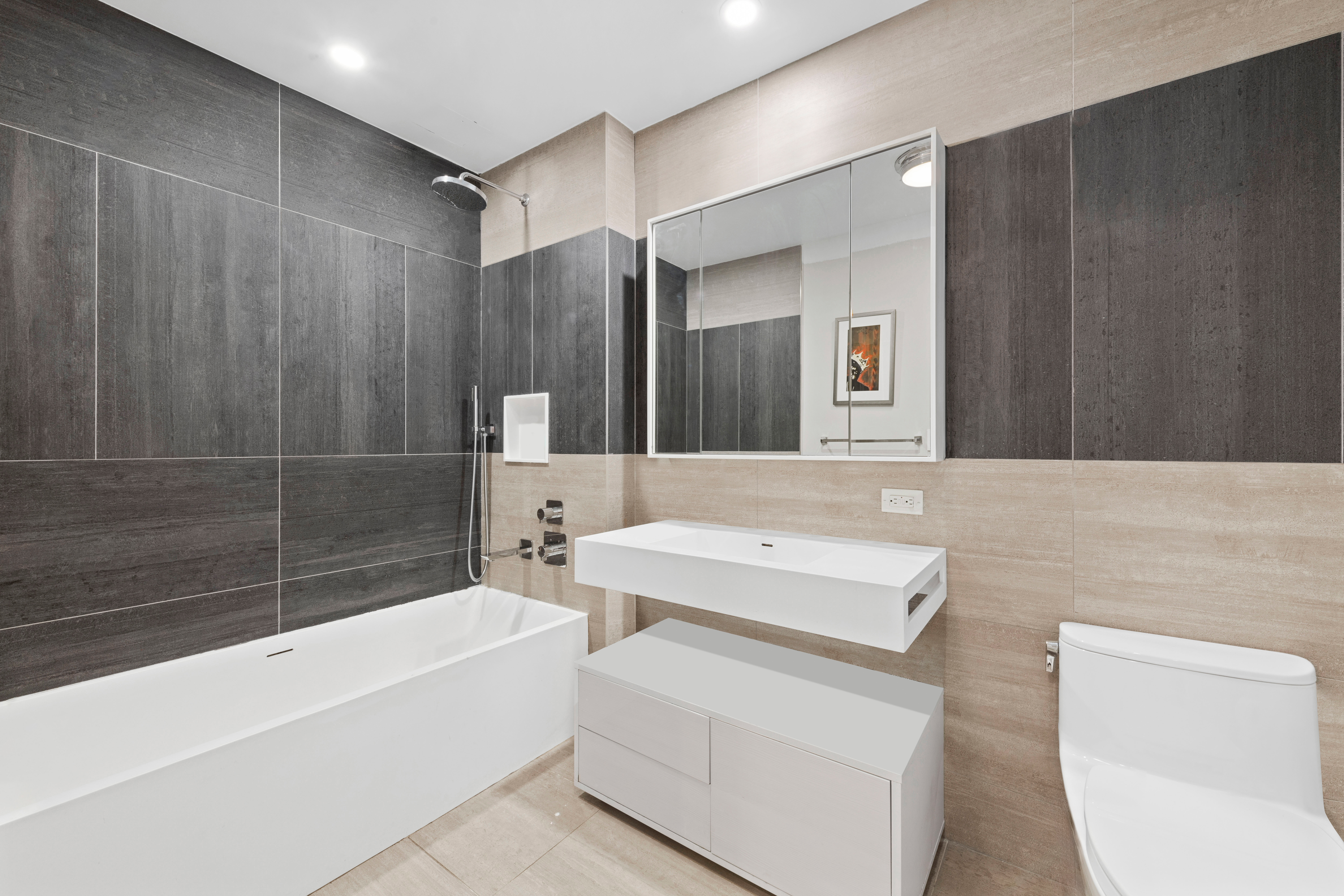 540 West 49th Street, Unit 401S Manhattan, NY 10019 - Photo 10 of 14 a bathroom with a sink a mirror and a bathtub