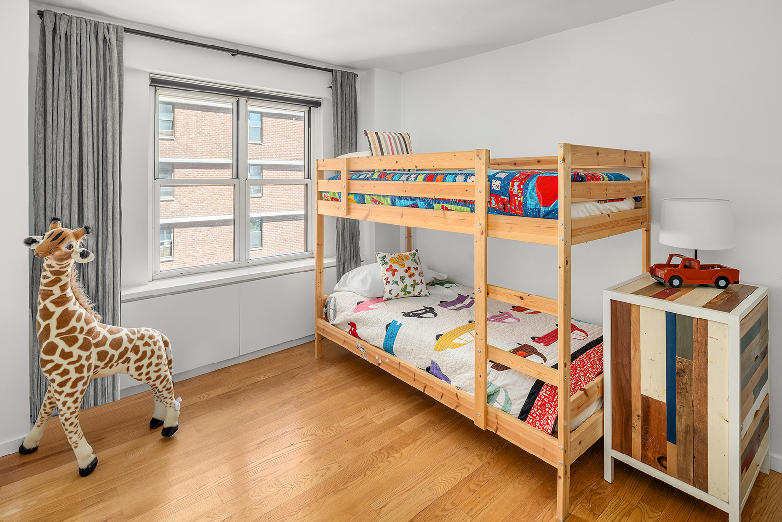 383 Grand Street, Unit M1304 Manhattan, NY 10002 - Photo 8 of 9 a bedroom with baby bed and a window