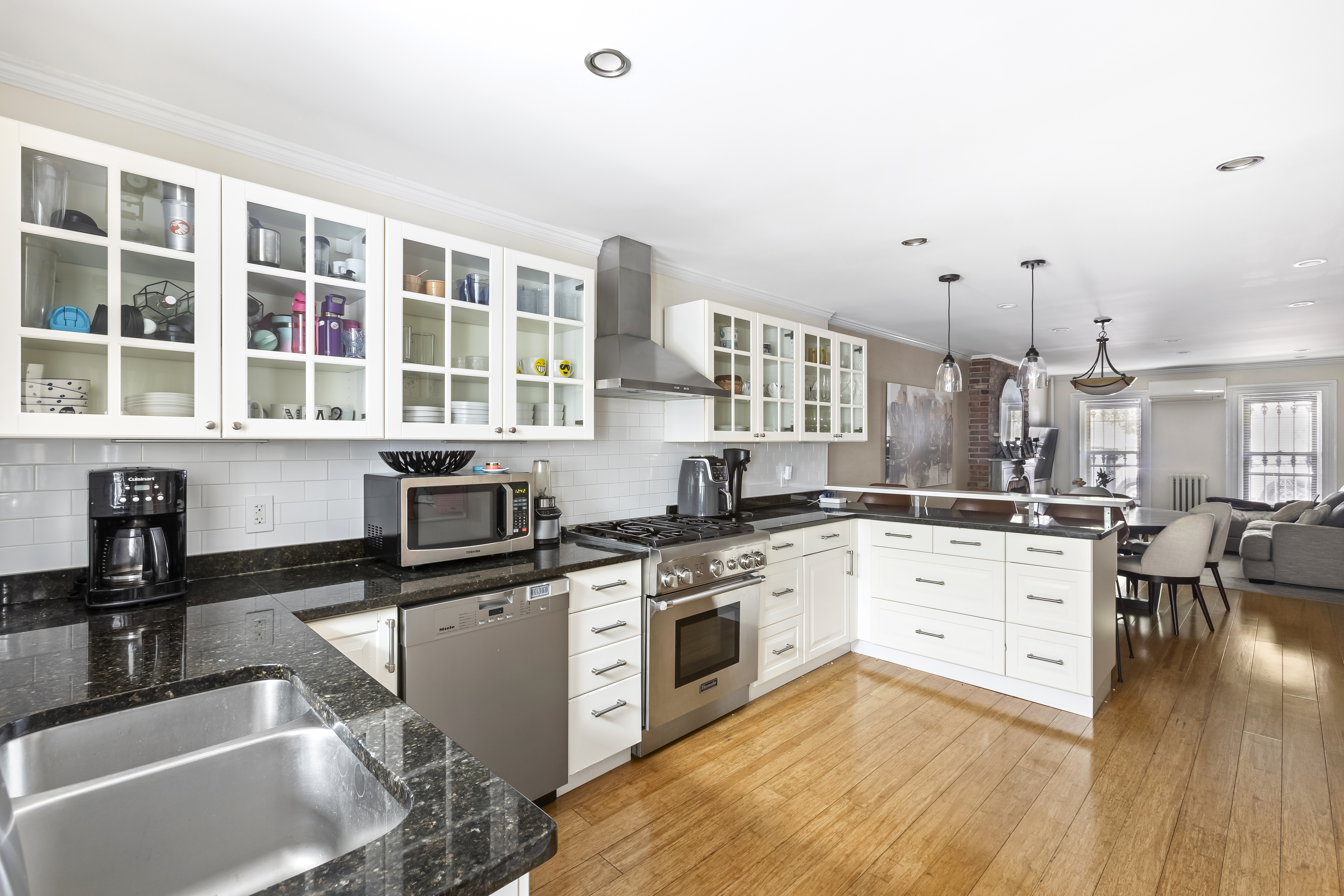 312 10th Street Brooklyn, NY 11215 - Photo 9 of 17 a kitchen with granite countertop a sink cabinets and wooden floor