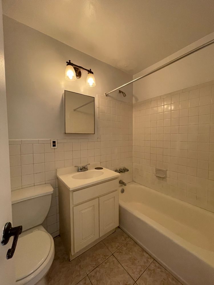 1280 Dean Street, Unit 3E Brooklyn, NY 11216 - Photo 3 of 5 a bathroom with a toilet sink and mirror