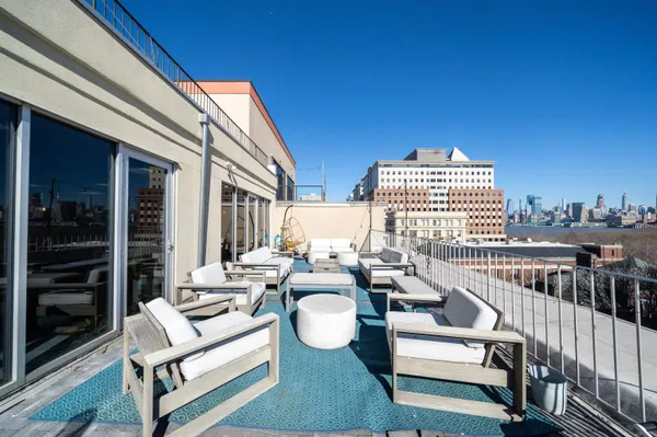 a view of a balcony with chairs and a potted plant
