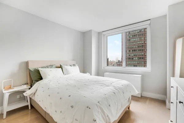 a large bed sitting in a bedroom next to a window