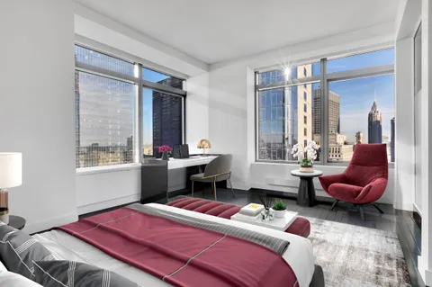 a bedroom with a bed and large windows