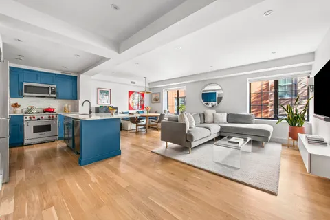 a living room with kitchen island furniture and a flat screen tv