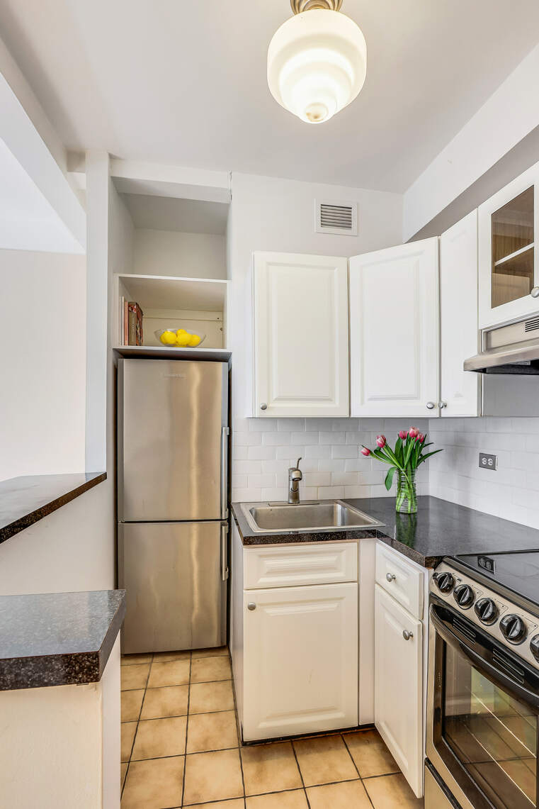23 West 73rd Street, Unit 1405A Manhattan, NY 10023 - Photo 6 of 9 a kitchen with a white cabinets sink and white appliances