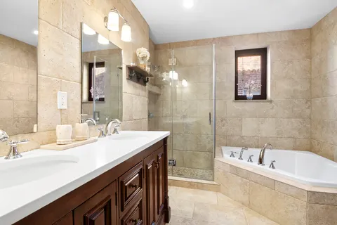 a bathroom with a tub a sink and mirror