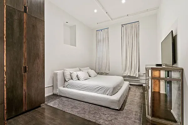 a bedroom with a bed window and a flat screen tv