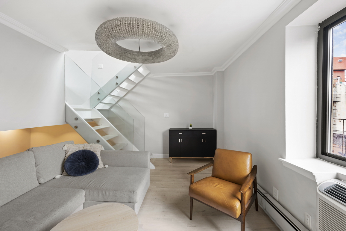 160 East 26th Street, Unit 6B Manhattan, NY 10010 - Photo 2 of 10 a living room with furniture and a chandelier