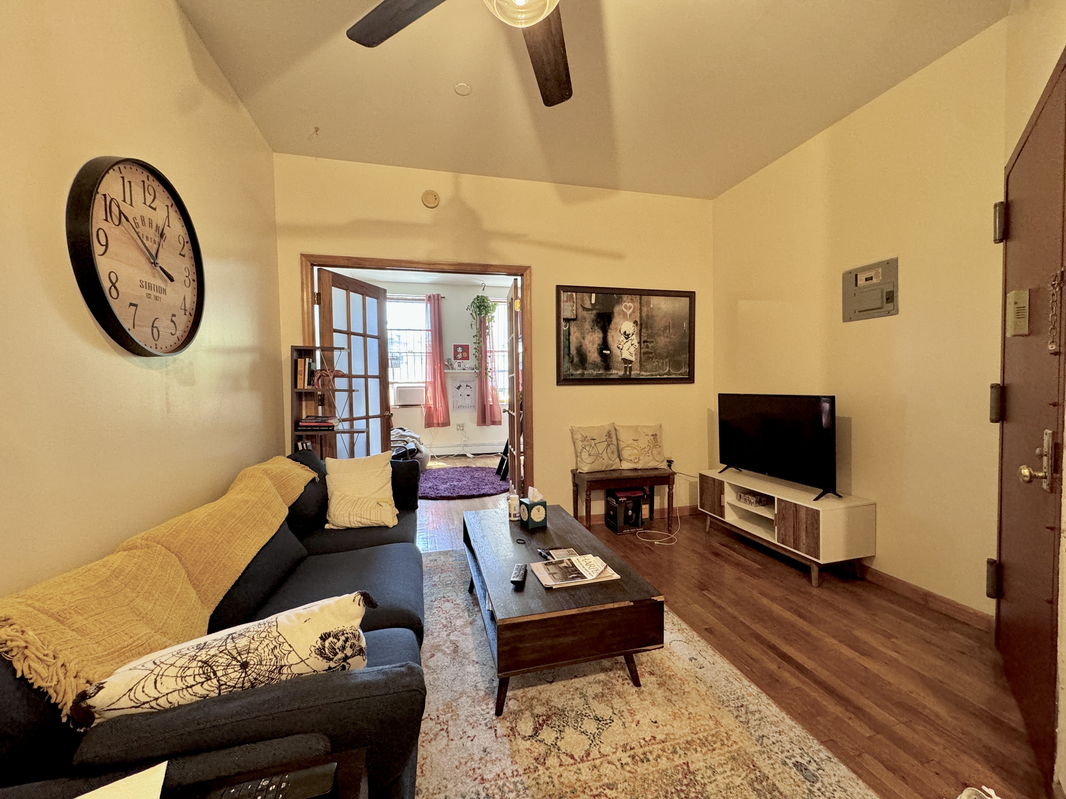 379 Baltic Street, Unit Undisclosed Brooklyn, NY 11201 - Photo 6 of 10 a living room with furniture a flat screen tv and a wall clock