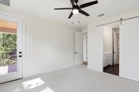 a view of a big room with a chandelier fan and closet area