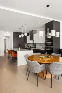 a kitchen with stainless steel appliances kitchen island granite countertop a sink a stove a dining table and chairs