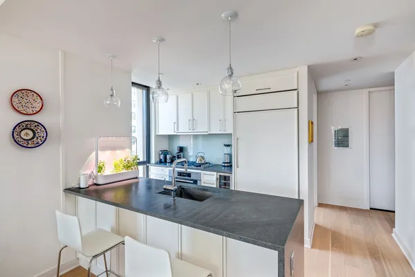 a kitchen with stainless steel appliances granite countertop a sink a stove and a refrigerator