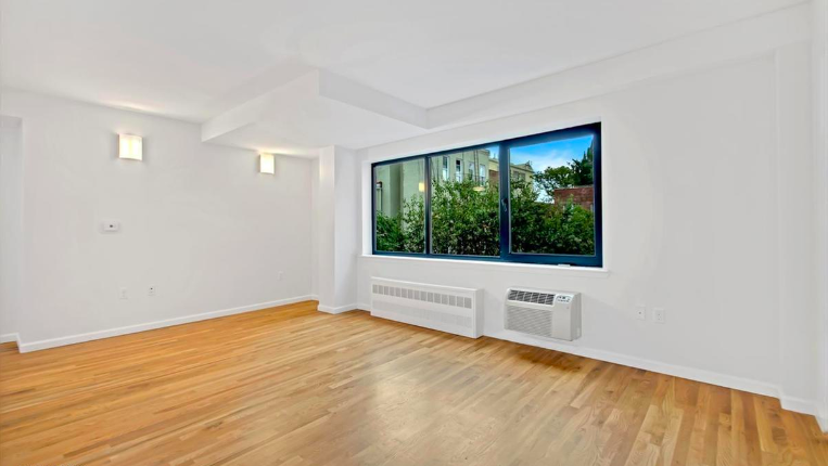 265 Van Brunt Street, Unit 1C Brooklyn, NY 11231 - Photo 2 of 7 a view of an empty room with wooden floor and a window