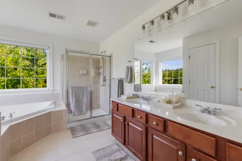 a spacious bathroom with a tub sink and mirror