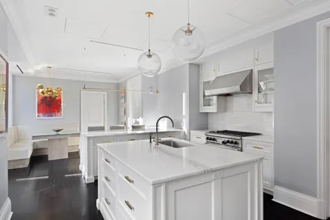 a kitchen with stainless steel appliances a sink a stove and a wooden floors