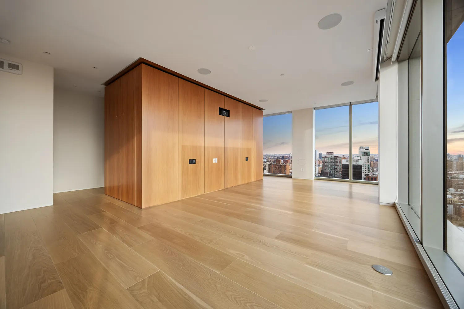 a view of a livingroom with wooden floor and a refrigerator