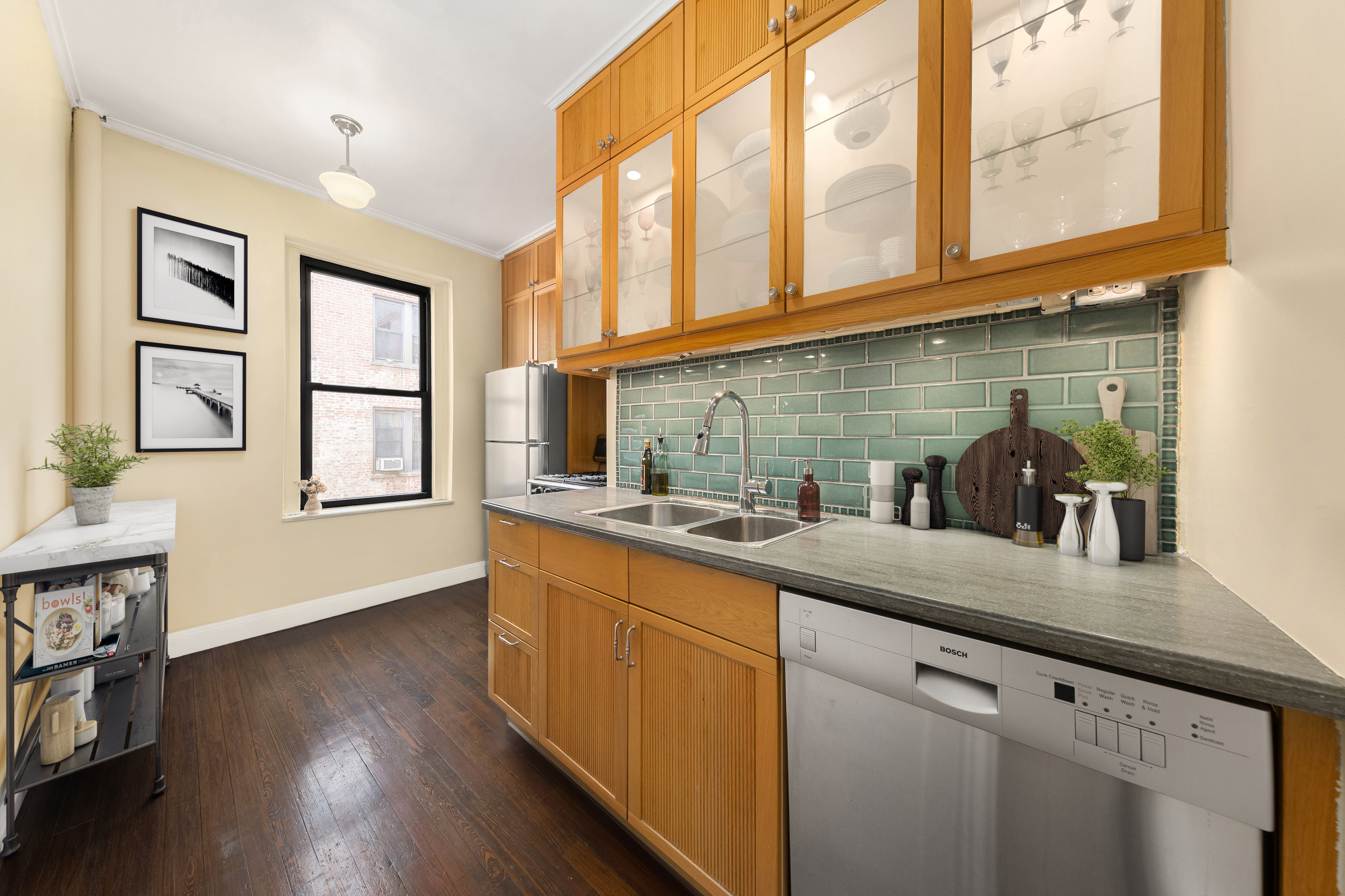 305 East 88th Street, Unit 5G Manhattan, NY 10128 - Photo 3 of 14 a kitchen with stainless steel appliances granite countertop a sink a oven and wooden cabinets with wooden floor