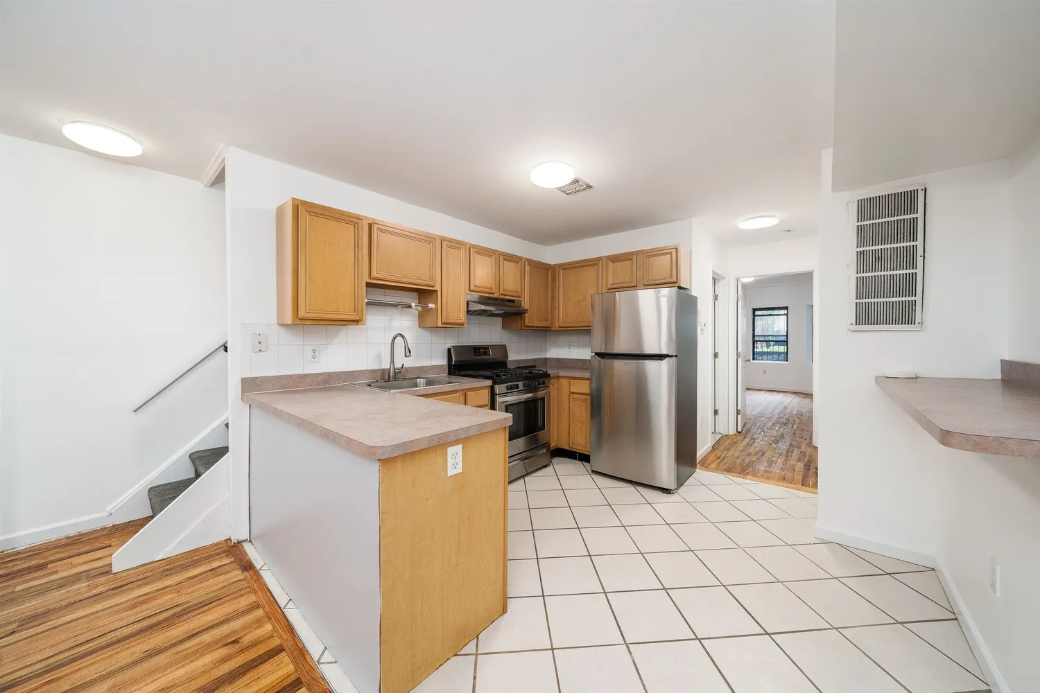 a kitchen with a refrigerator a stove top oven and a sink