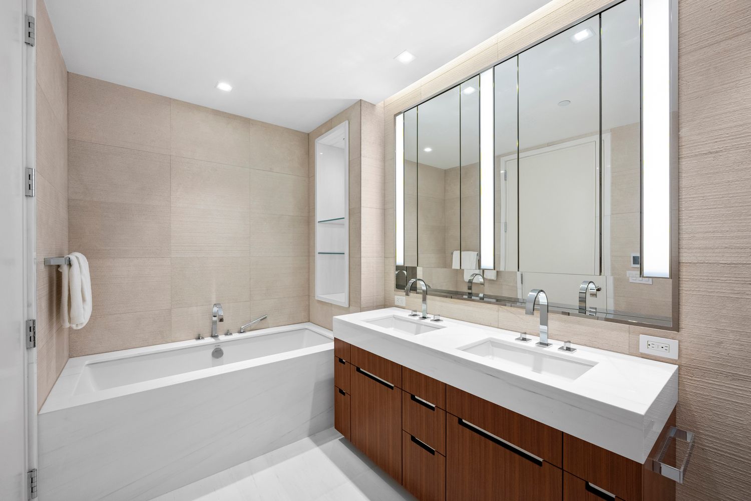 a bathroom with a double vanity sink mirror and a bathtub