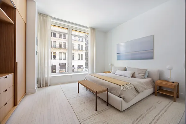 a bedroom with a bed a mirror and a window