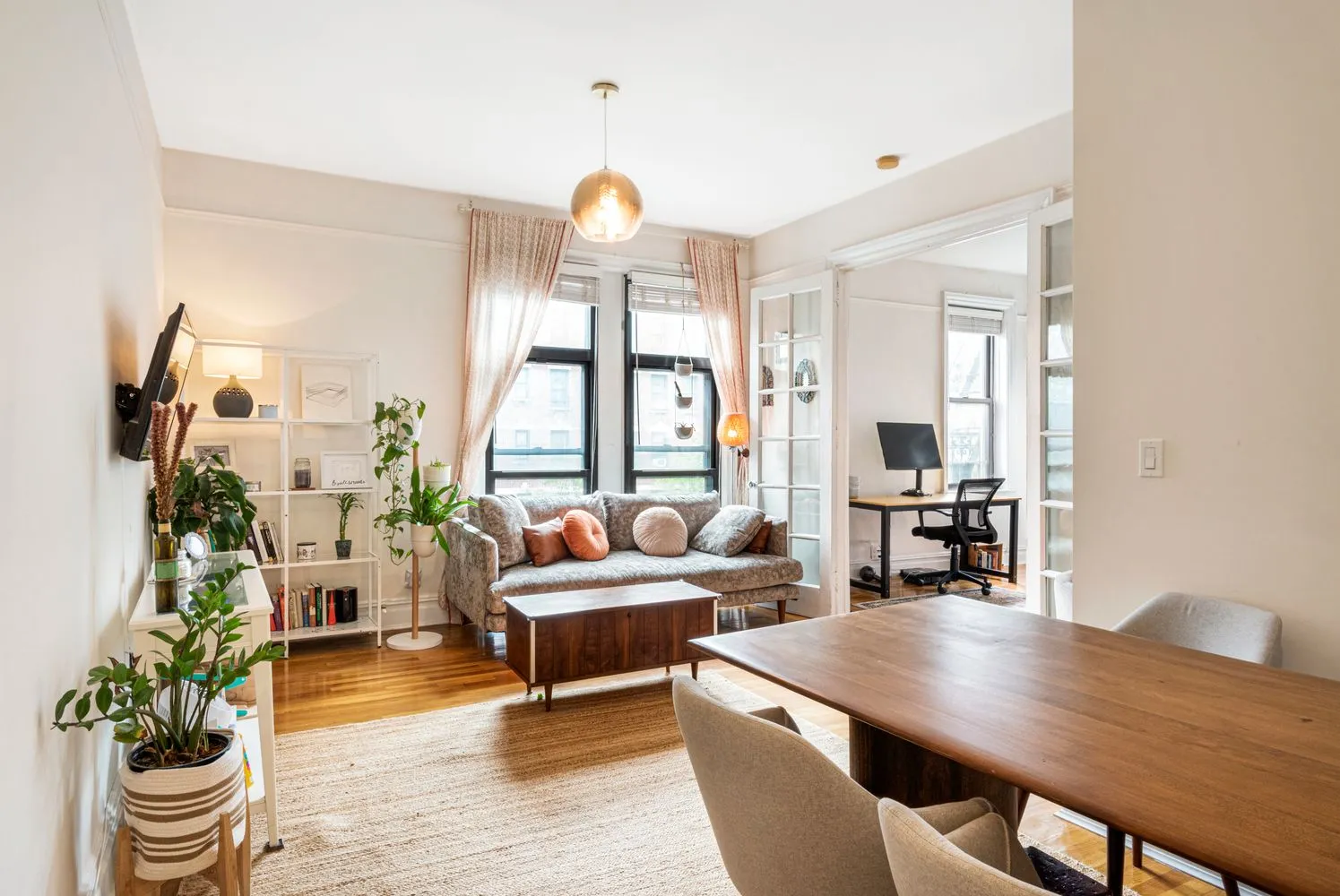 a living room with furniture potted plant and open kitchen view